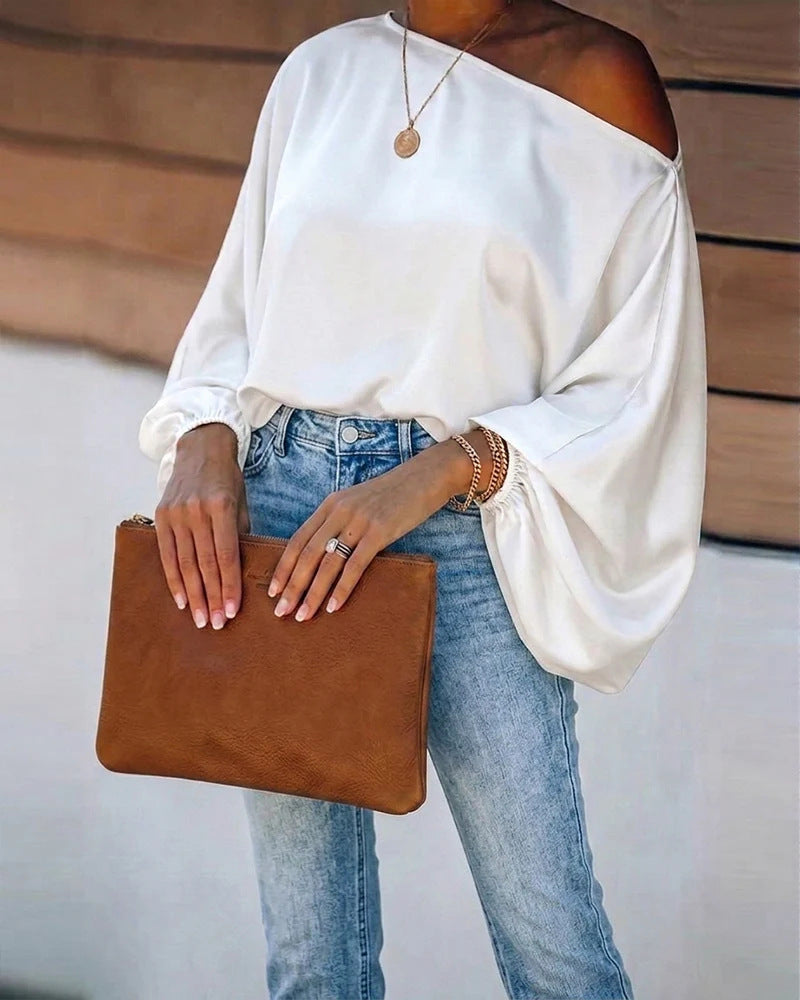 Satijnen damesblouse met asymmetrische off-shoulder halslijn en brede vleermuismouwen