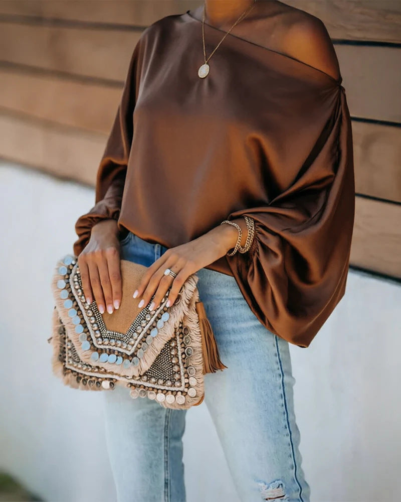 Satijnen damesblouse met asymmetrische off-shoulder halslijn en brede vleermuismouwen