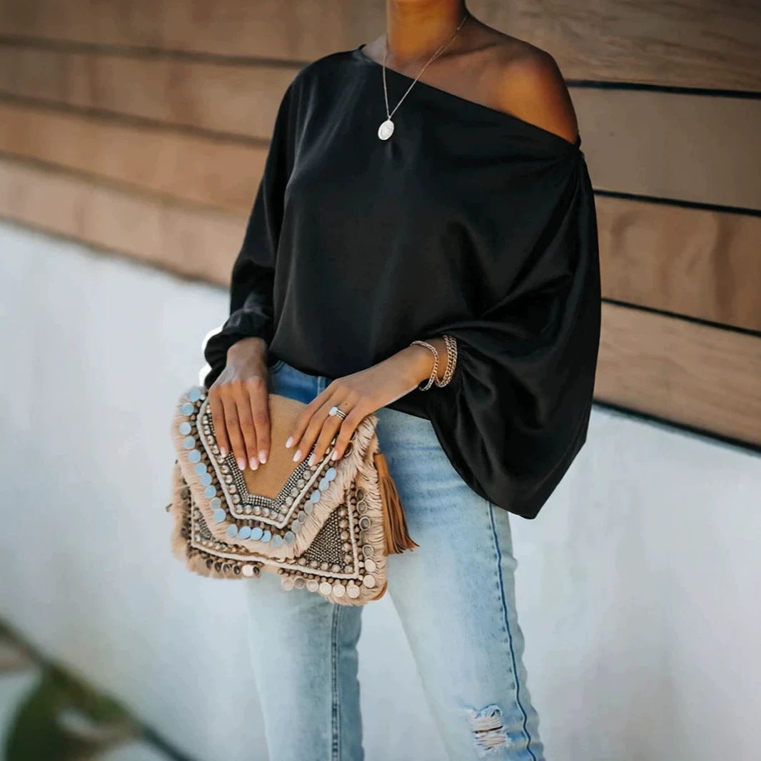 Satijnen damesblouse met asymmetrische off-shoulder halslijn en brede vleermuismouwen